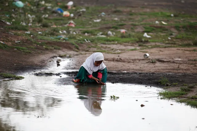 A girl plays near a rain water at a camp for internally displaced people near Sanaa, Yemen, August 10, 2016. (Photo by Khaled Abdullah/Reuters)