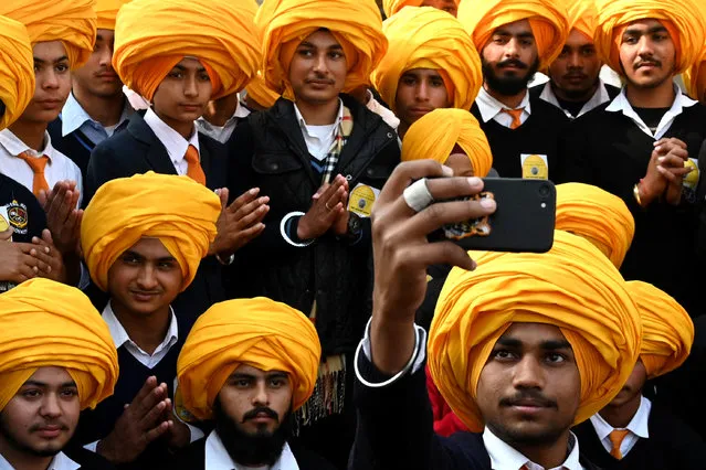 Sikh boys take a selfie using a mobile phone during a national level Turban tying event held at the Golden Temple in Amritsar on December 18, 2022. (Photo by Narinder Nanu/AFP Photo)