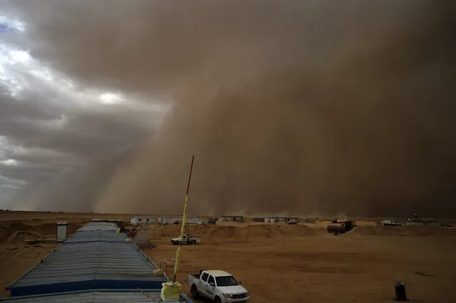 A sandstorm sweeps a highway construction site in the desert on the outskirts of Beheira, 180 kilometers (112 miles) north of Cairo, Egypt, Tuesday, October 6, 2015. (Photo by Mahmood Shahiin/AP Photo)