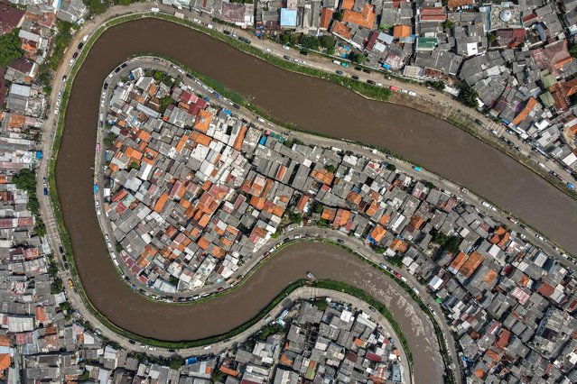 This aerial picture shows a river running through a residential area in Jakarta on May 9, 2025. (Photo by Bay Ismoyo/AFP Photo)