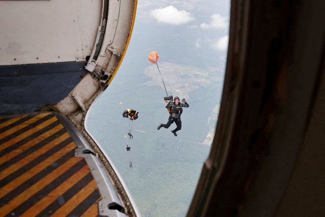 Canopies begin to open as members of the U.S. Army Parachute Team, known as the Golden Knights, descend after jumping from their plane over Laurinburg-Maxton Airport as the group continues to train before some members parachute into Washington D.C. as part of the army's upcoming 250th anniversary celebrations, in Maxton, North Carolina on June 4, 2025. (Photo by Jonathan Drake/Reuters)