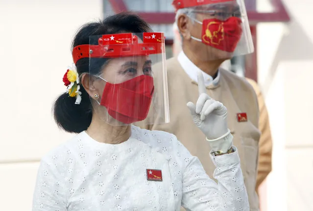 Myanmar leader Aung San Suu Kyi gestures while wearing a face shield, mask and gloves during a flag-raising ceremony to mark the first day of election campaigning at the National League for Democracy party's temporary headquarters in Naypyitaw, Myanmar on Tuesday, September 8, 2020. Myanmar holds a general election on Nov. 8 and began a sixty-day election campaign period Tuesday, which may be disrupted due to a resurgence of the coronavirus. (Photo by Aung Shine Oo/AP Photo)