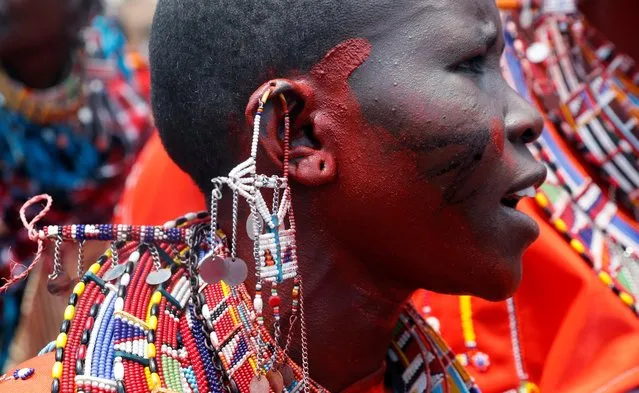 A Maasai woman sings for their men of Matapato clan before attending the Olng'esherr (meat-eating) passage ceremony to unite two age-sets; the older Ilpaamu and the younger Ilaitete into senior elder-hood as the final rite of passage, after the event was initially postponed due to the coronavirus disease (COVID-19) outbreak in Maparasha hills of Kajiado, Kenya on September 23, 2020. (Photo by Thomas Mukoya/Reuters)