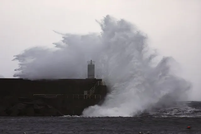 Waves break against a harbor breakwater during a storm along the Galician coast in A Guarda, Pontevedra, Spain, 19 December 2022. (Photo by Sxenick/EPA/EFE)