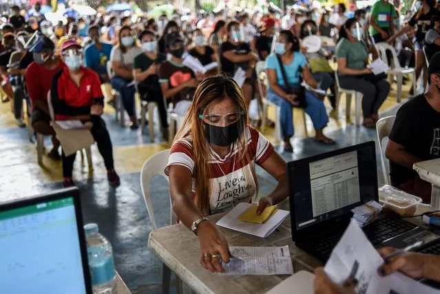 People wearing face shields and face masks queue during the distribution of government cash aid in Quezon City, Philippines on September 10, 2020.(Photo by Lisa Marie David/NurPhoto via Getty Images)