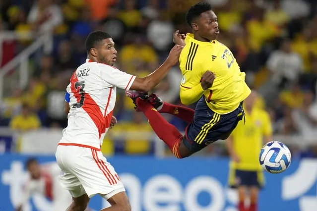 Peru's Jose Sanchez, left, and Colombia's Jorge Cabezas, battle for the ball during a South America U-20 soccer match in Cali, Colombia, Saturday, January 21, 2023. (Photo by Fernando Vergara/AP Photo)