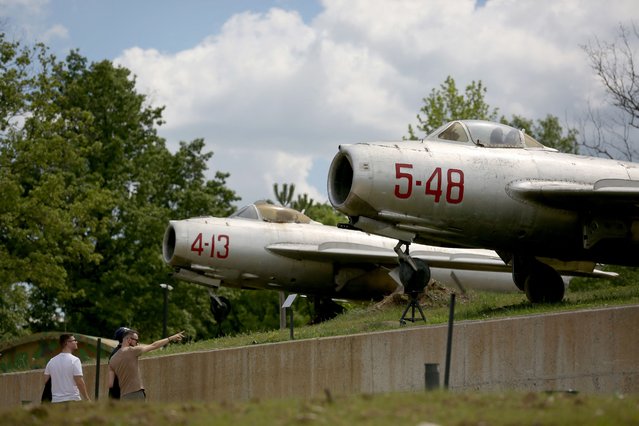 Visitors watch at the Russian and Chinese made military planes in the front yard of the Albanian army museum in Berzhite, near the capital of Tirana, on April 20, 2024. The Albanian army museum in Berzhite, near the capital Tirana, showcases everything from Soviet tanks and Chinese torpedo launchers to home-made weapons and NATO flags. (Photo by Adnan Beci/AFP Photo)