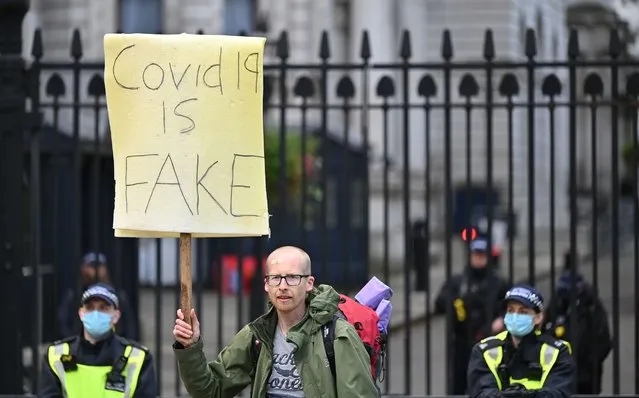 A demonstrator holds a placard at a protest action against restrictions imposed during the novel coronavirus COVID-19 pandemic, outside Downing Street, central London on October 10, 2020. British Prime Minister Boris Johnson is expected next week to outline a new three-tier lockdown system as rates of coronavirus infection surge particularly in northern England. (Photo by Justin Tallis/AFP Photo)