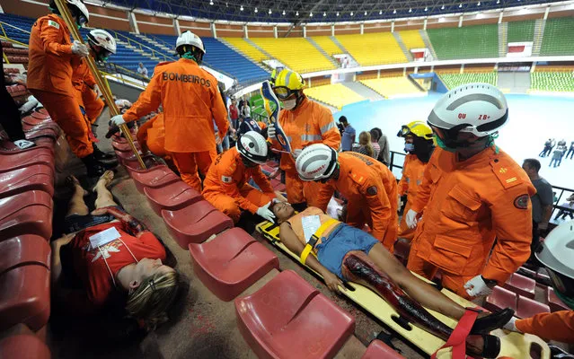 Rescuers participate in an exercise of emergency care of injured fans in football stadiums in Brasilia, on March 20, 2013. Rescuers from several Brazilian states participated in a simulated exercise aimed at the FIFA 2013 Confederations Cup and FIFA 2014 World Cup. (Photo by Evaristo Sá/AFP Photo)