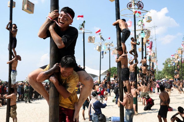 Participants react as they try to reach the top of a greased pole to collect the prizes, during a “Panjat Pinang” competition celebrating Indonesia's 80th Independence Day, at Ancol in Jakarta, Indonesia on August 17, 2025. (Photo by Ajeng Dinar Ulfiana/Reuters)