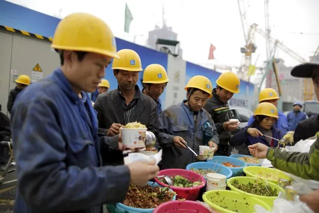 Workers get their lunch outside a construction site in the Central Business District (CBD) area, in Beijing, China, October 26, 2015. China's Premier Li Keqiang said China requires annual growth of at least 6.53 percent over the next five years, Bloomberg reported, citing unidentified sources. Chinese leaders are meeting in Beijing to decide on an economic growth target for the next five years. (Photo by Jason Lee/Reuters)