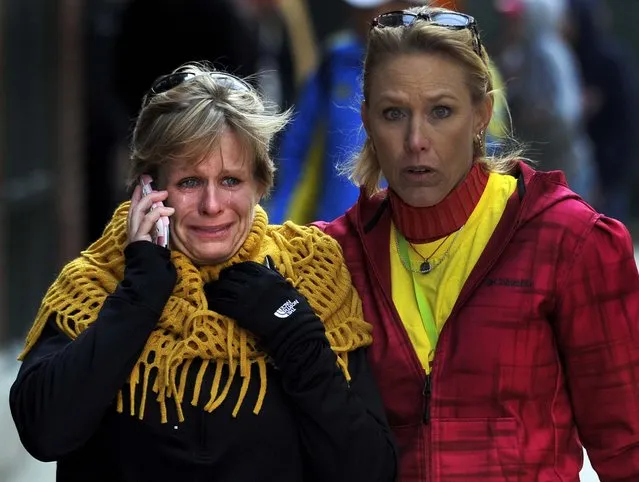 Women react as they walk from the area of the explosions. (Photo by Josh Reynolds/Associated Press)