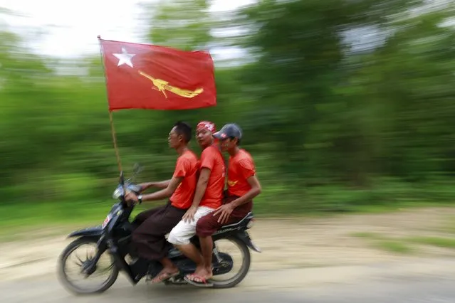 Supporters ride a bike during Myanmar pro-democracy leader Aung San Suu Kyi's campaign rally for the upcoming general elections in her constituency town Kawhmu township, Yangon Division, October 24, 2015. (Photo by Soe Zeya Tun/Reuters)