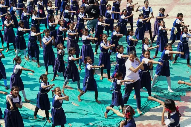 An instructor (in white) leads schoolgirls during a martial arts class for self-defence at a school in Ahmedabad on March 16, 2023. (Photo by Sam Panthaky/AFP Photo)