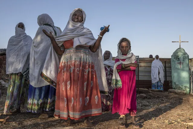 Women who fled the conflict in Ethiopia's Tigray region, prays after Mass at a nearby church in the Umm Rakouba refugee camp in Qadarif, eastern Sudan, Sunday, November 29, 2020. (Photo by Nariman El-Mofty/AP Photo)