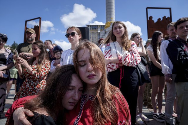 Young women hug each other during a memorial service for the Ukrainian journalist and volunteer combat medic Iryna Tsybukh on Independence square in Kyiv, Ukraine, Sunday, June 2, 2024. Nearly 1,000 people attended a ceremony Sunday honoring the memory of Ukrainian journalist Iryna Tsybukh, who was killed in action while serving as a combat medic a few days before her 26th birthday. Tsybukh was killed while on rotation in Kharkiv area, where Russia started its offensive nearly a month ago. (Photo by Evgeniy Maloletka/AP Photo)