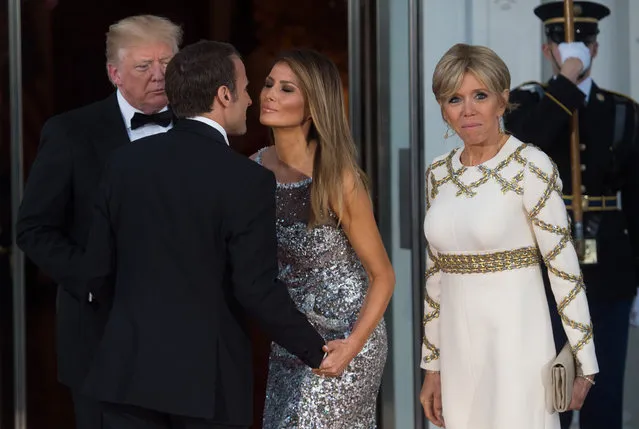 US President Donald Trump and First Lady Melania Trump welcome French President Emmanuel Macron and his wife, Brigitte Macron, as they arrive for a State Dinner at the North Portico of the White House in Washington, DC, April 24, 2018. (Photo by Saul Loeb/AFP Photo)