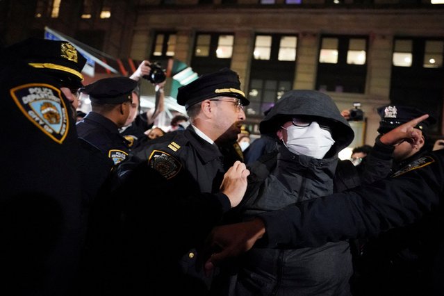 Police officers detain a person outside 26 Federal Plaza, where migrants who were detained during a raid in Lower Manhattan by ICE were brought in, in Manhattan, New York, U.S., October 21, 2025. (Photo by David Dee Delgado/Reuters)