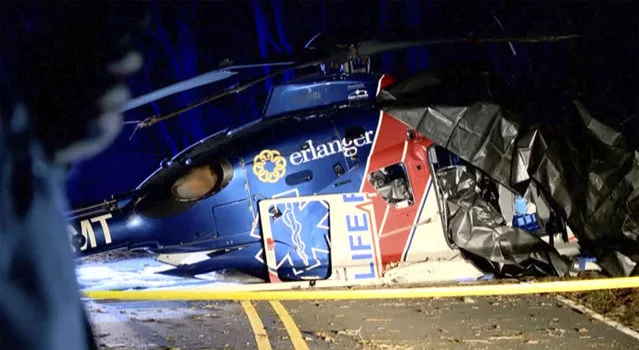 This image from a video shows a wrecked helicopter in Macon Country, N.C. Friday, March 10, 2023. A patient and three crew members survived when the medical transport helicopter crashed Thursday evening. (Photo by WLOS-TV via AP Photo)
