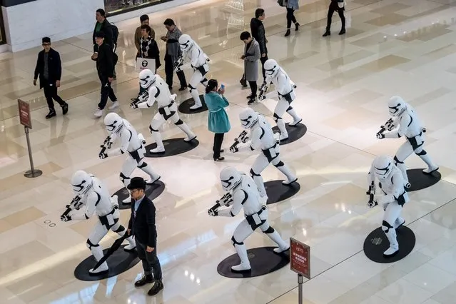 People look at life-size sculptures of Stormtroopers from the "Star Wars" movies at IAPM Shopping Mall on November 24, 2015 in Shanghai, China. (Photo by ChinaFotoPress via Getty Images)