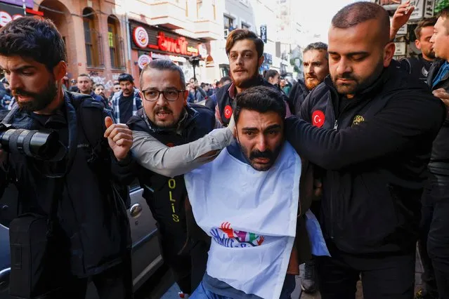 Police officers detain a demonstrator as people protest to defy a ban and march on Taksim Square to celebrate May Day in Istanbul, Turkey on May 1, 2023. (Photo by Kemal Aslan/Reuters)