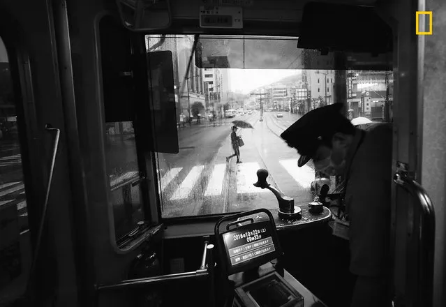 First Place Winner, Cities: Another rainy day in Nagasaki, Japan. “This is a view of the main street from a tram in Nagasaki on a rainy day. The tram is vintage, but retrofitted with modern ticketing equipment. A conductor is no longer on board – only the lone driver. The quiet streetscape seen through the front windshield of the tram somehow caught my attention. This view presents quite a contrast to busy urban centers in Japan, such as Tokyo and Osaka. The ride on a vintage tram through the relatively quiet main street was a memorable experience during our week-long visit to the historic city of Nagasaki”. (Photo by Hiro Kurashina/National Geographic Travel Photographer of the Year Contest)
