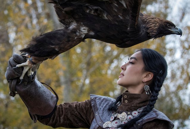 A hunter holds her tamed golden eagle during a traditional hunting contest near the village of Tole Bi in Almaty region, Kazakhstan on November 8, 2024. (Photo by Pavel Mikheyev/Reuters)