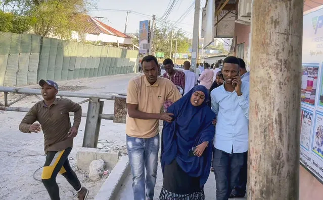 In this image made from video, people flee from the area as gunshots are heard, on a street near the Afrik hotel in the capital Mogadishu, Somalia Sunday, January 31, 2021. The hotel in Somalia's capital has been hit by an explosion and an attack by gunmen, according to police. (Photo by AP Photo/Stringer)