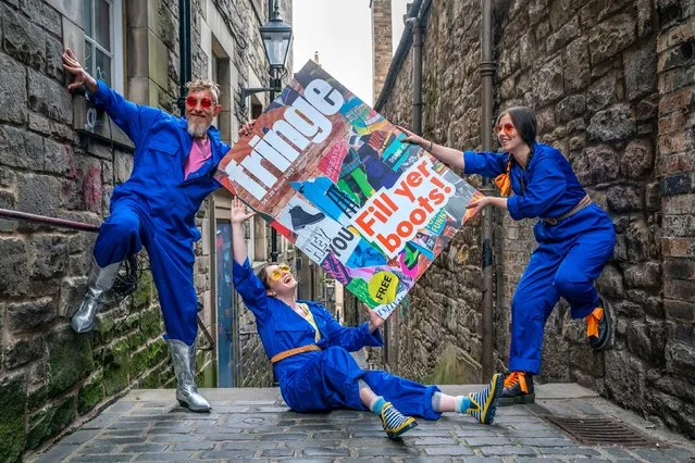 Cris Peploe, Claudia Cawthorne and Martha Haskins pose with a large-scale version of the Edinburgh Festival Fringe 2023 programme cover during the launch in Anchor Close, Edinburgh on Tuesday, June 6, 2023. (Photo by Jane Barlow/PA Images via Getty Images)