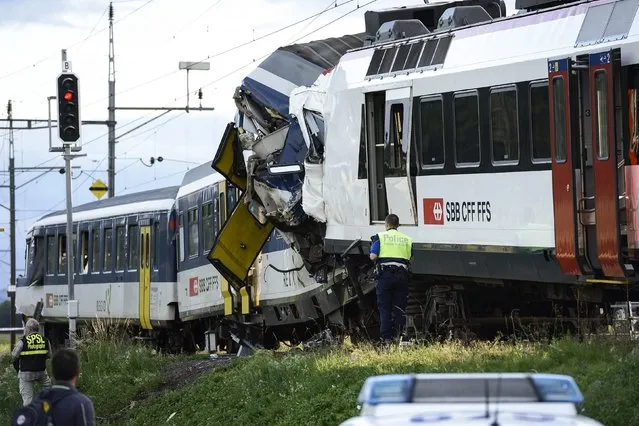 Police inspect the site where two passenger trains collided head-on in Granges-pres-Marnand, western Switzerland, Monday, July 29, 2013. Numerous people have been injured. (Photo by Laurent Gillieron/AP Photo/Keystone)