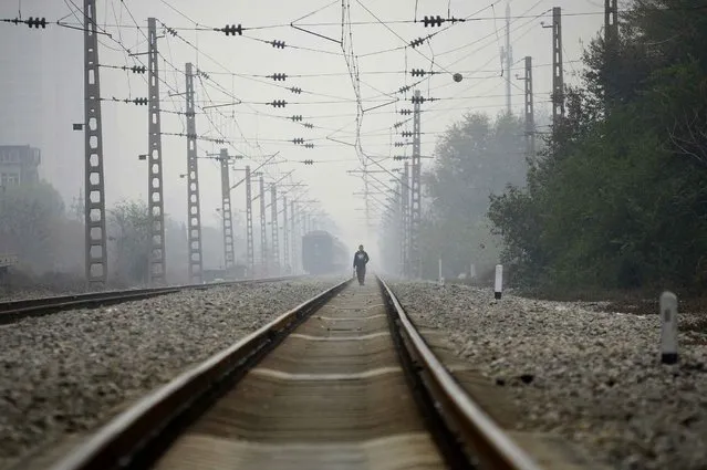 A man walks along a train track in Beijing on November 10, 2016. (Photo by Wang Zhao/AFP Photo)