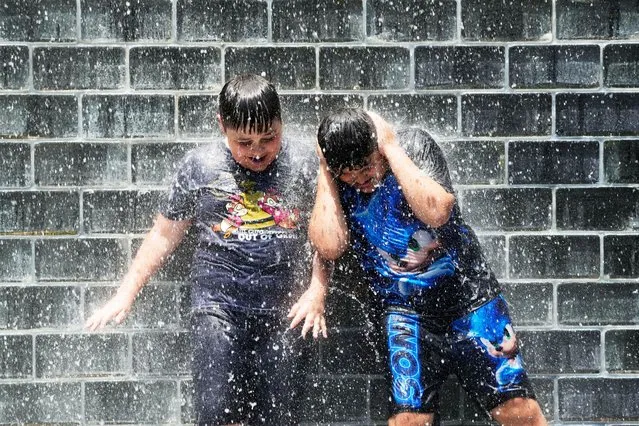 Children play in the Crown Fountain at Millennium Park in Chicago, Monday, July 3, 2023. (Photo by Nam Y. Huh/AP Photo)