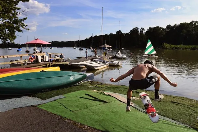 Employee Lorenzo Mahrez, 16, does a skateboard trick in between helping boaters at Belle Haven Marina in Alexandria, Va. on July 19, 2018. (Photo by Matt McClain/The Washington Post)