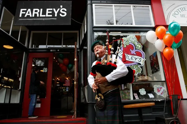 Lynne Miller plays the bagpipes for guests outside as Farley's Cafe marks its 32nd anniversary with bagpipes, Irish stew, and live music on St. Patrick's Day in San Francisco, California, March 17, 2021. Miller has played the bagpipes at every anniversary event of Farley's since they opened, except in 2020, when the event was cancelled due to the coronavirus pandemic. (Photo by Brittany Hosea-Small/Reuters)