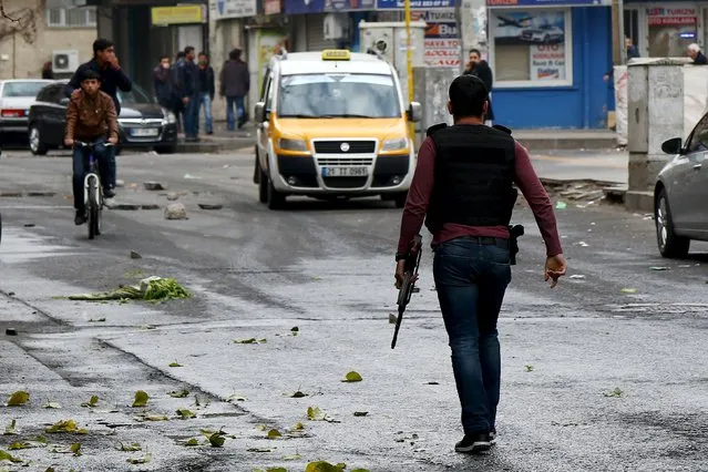 A plainclothes policeman is seen during a pro-Kurdish protest against the curfew in Sur district and security operations, in the southeastern city of Diyarbakir, Turkey, December 29, 2015. (Photo by Sertac Kayar/Reuters)