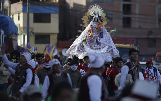 In this Sunday, August 5, 2018 photo, faithful take part in a religious procession honoring Our Lady of Copacabana, in Cuzco, Peru. The veneration of Bolivia's patron saint in Cuzco began a decade ago with a small feast among friends and family. Now an annual event, it has grown in popularity with as many as 500 people taking part. (Photo by Martin Mejia/AP Photo)