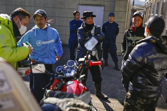 Policemen keep an eye on Bousouzoku bikers as they wait at the Dangouzaka rest stop in Yamanashi, west of Tokyo, Japan, January 3, 2016. (Photo by Thomas Peter/Reuters)