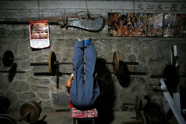A man works out at a gym which has been turned from a bicycle shed inside a residential compound in the southwest of Beijing, China on April 8, 2021. (Photo by Tingshu Wang/Reuters)