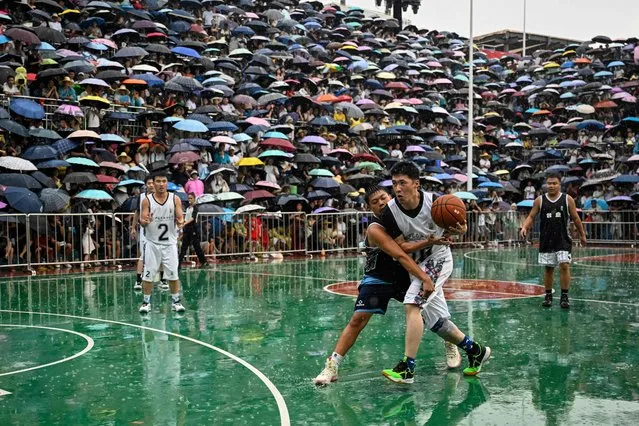 This photo taken on July 30, 2023 shows players competing during an invitational game of the grassroots basketball competition CunBA in Taipan village, Taijiang county, in southwestern China's Guizhou province. Athletes in the “CunBA” – with “cun” meaning village in Chinese – are all amateurs, and the prizes are simple platters of roast meat. But it's the pure electricity of the games that keeps fans and players hooked, rising in recent years from a humble local tradition into a viral hit and staple of Beijing's propaganda machine. (Photo by Jade Gao/AFP Photo)