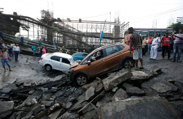 People stand next to the wreckage of vehicles at the site of a bridge that collapsed in Kolkata, September 4, 2018. (Photo by Rupak De Chowdhuri/Reuters)