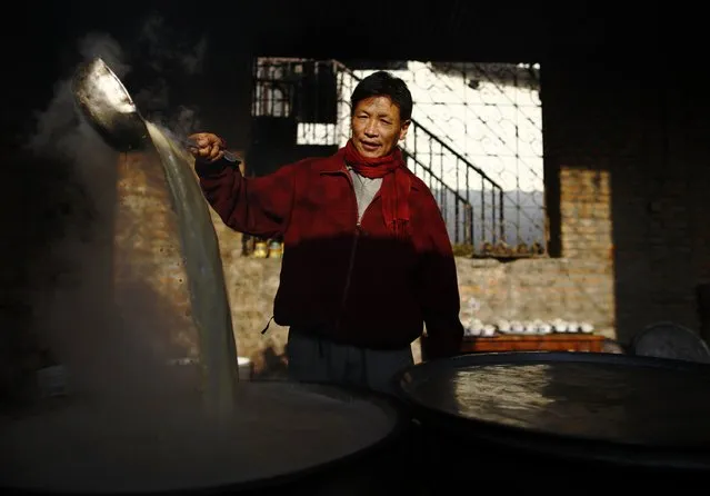 A Tibetan man stirs butter tea made for the arriving guest during the function organised to mark Losar or the Tibetan New Year at a Tibetan Refugee Camp in Lalitpur February 19, 2015. (Photo by Navesh Chitrakar/Reuters)