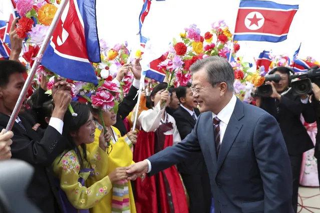 South Korean President Moon Jae-in, right, is greeted by North Koreans during a welcome ceremony at Sunan International Airport in Pyongyang, North Korea, Tuesday, September 18, 2018. (Pyongyang Press Corps Pool via AP Photo)