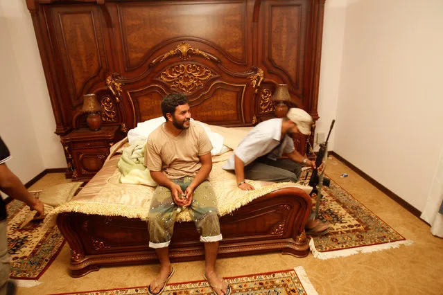 Anti-Gaddafi forces sit on a bed at Muammar Gaddafi's farm house near the town of Abu Grein  in the last remaining stronghold of Muammar Gaddafi, west of Sirte August 30, 2011. (Photo by Goran Tomasevic/Reuters)