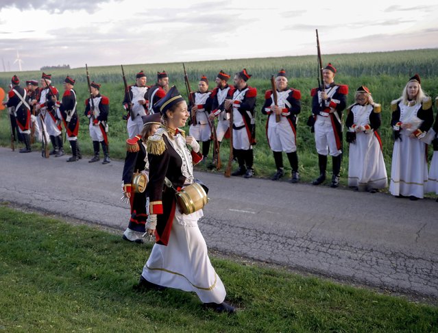 Pilgrims and people dressed with Second French Empire uniforms take part in the procession of “Marche Sainte-Rolende”, in Gerpinnes, Belgium, 06 June 2022. The event is part of some 15 folkloric marches in Entre-Sambre-et-Meuse, recognized as intangible cultural heritage by the UNESCO (United Nations Educational, Scientific and Cultural Organisation). The march of Sainte-Rolende, both a religious and secular event, is the biggest one. Starting at 2h30 am with a religious service, more than 3,000 pilgrims joined a procession of some 35km passing through seven villages while carrying the 58kg shrine with the relics of Sainte-Rolende, which were placed in a new reliquary in 1599. First traces of the Sainte-Rolende in Gerpine date back to 1699. (Photo by Olivier Hoslet/EPA/EFE)