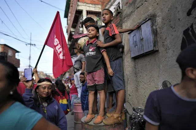 Boys stand atop a barrel during a rally in support of President Nicolas Maduro, at the 23 de Enero neighborhood in Caracas, Venezuela, Thursday, July 13, 2023. (Photo by Ariana Cubillos/AP Photo)