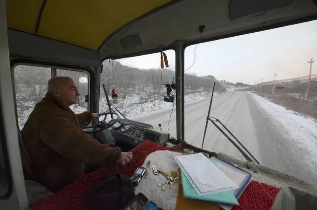 A man drives a passenger bus along a road on the Island of Shikotan, one of four islands known as the Southern Kuriles in Russia and the Northern Territories in Japan, December 19, 2016. (Photo by Yuri Maltsev/Reuters)