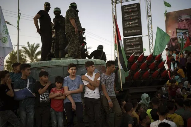 Palestinians gather as Hamas militants parade at a rally just over a week after a cease-fire was reached in an 11-day war between Hamas and Israel, Sunday, May 30, 2021, in Beit Lahia, northern Gaza Strip. (Photo by Felipe Dana/AP Photo)