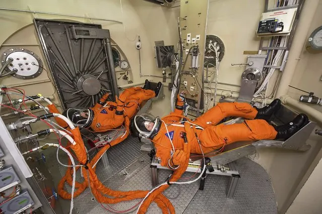 Member of the Johnson Space Center team participate in Vacuum Pressure Integrated Suit testing of the spacesuit astronauts will wear during Orion spacecraft missions into deep space in this March 17, 2015 handout photo at the Johnson Space Center in Houston, Texas provided by NASA March 19, 2015. Astronauts will board the Orion spacecraft for the first crewed flight in 2021 according to NASA. (Photo by Bill Stafford/Reuters/NASA)