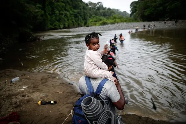 Migrants cross the Turquesa river in the Darien jungle, in Panama, 14 September 2023. After having crossed the jungle for several days, with its muddy hills, rivers of sudden flooding and the threat of snake bites or robberies, the migrants arrive at the indigenous town of Bajo Chiquito, where the authorities register them. According to official data provided by Panama, more than 385,000 people have crossed Darien so far this year, a record number compared to 248,000 in all of 2022, the highest record to date. Furthermore, if the trend continues, Panamanian authorities already predict that it will reach 500,000 people. (Photo by Bienvenido Velasco/EPA/EFE)