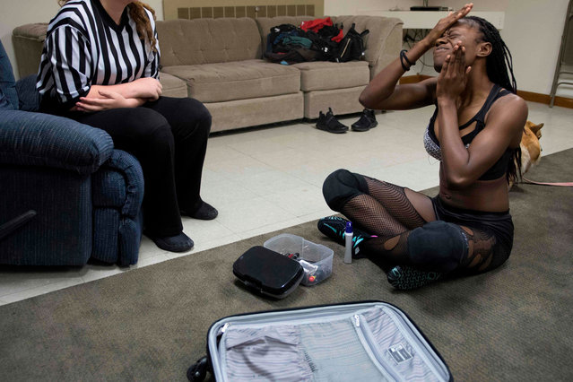 Professional wrestler Gia Scott (R) puts on make up for Autumn Armageddon 2018 as she goes through her match with a MCW referee prior to her match at a firehouse in Galena, Maryland on October 6, 2018. (Photo by Jim Watson/AFP Photo)